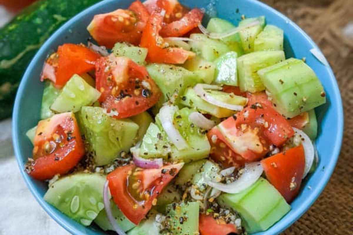 Vibrant cucumber, tomato and onion salad in a bowl.