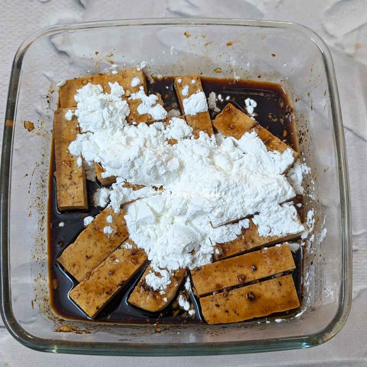 Tofu fries with cornstarch after marination in a bowl
