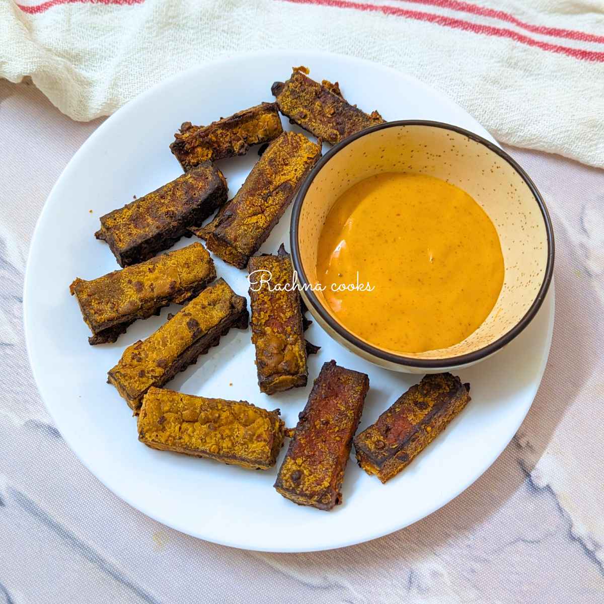 Tofu fries served on a white plate with a dip