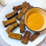 Tofu fries served on a white plate with a dip