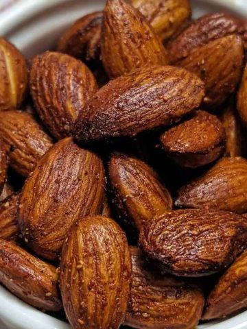 Roasted almonds served in a white bowl