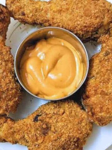 Fried chicken drumsticks on a plate with dip