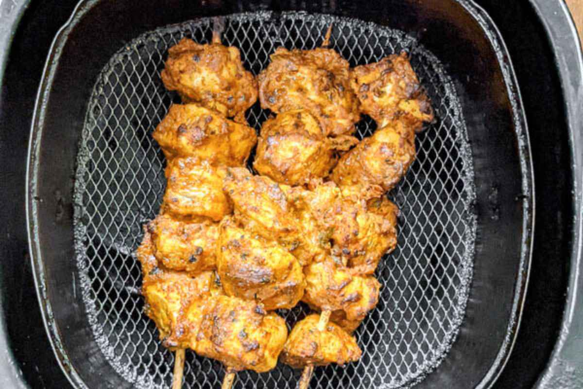 3 chicken tikka skewers in air fryer basket