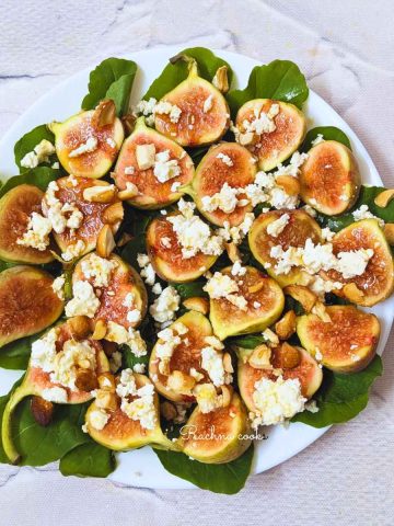 Fig and goat cheese with arugula salad on a plate
