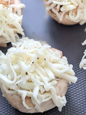 Delicious cheesy mushrooms on a board