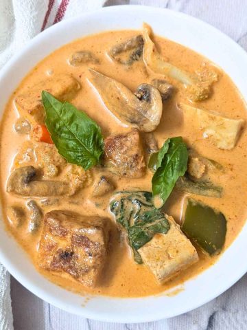 Thai red curry with crispy tofu served in a white bowl
