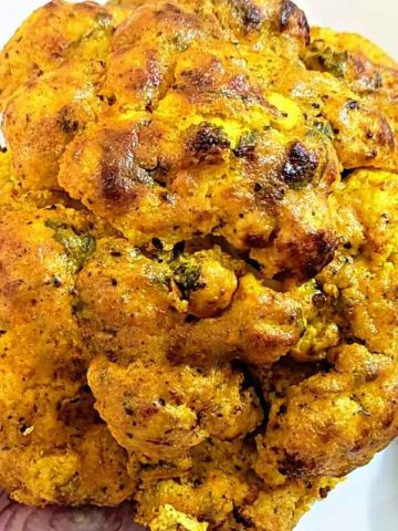 Whole cauliflower served on a white plate