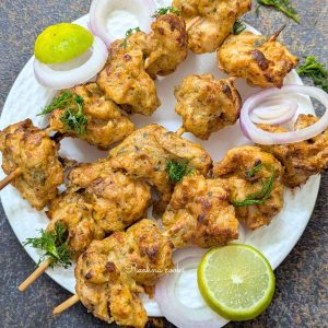 Chicken malai tikka skewers on a plate.