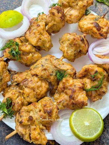 Chicken malai tikka skewers on a plate.