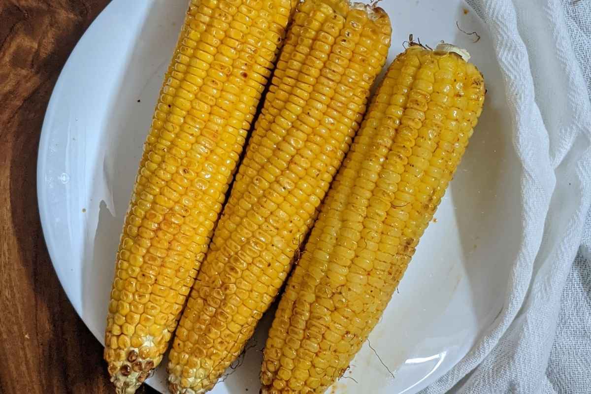 3 corn on the cob on a plate.