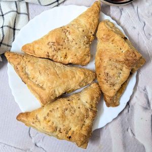 Four paneer puffs served on a plate