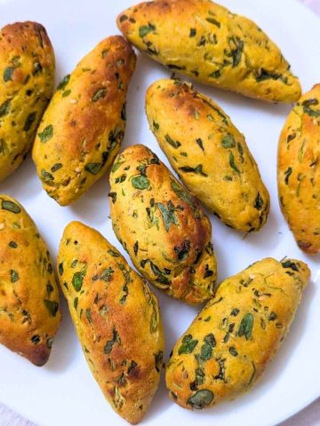 Delicious methi muthia cylinders on a plate