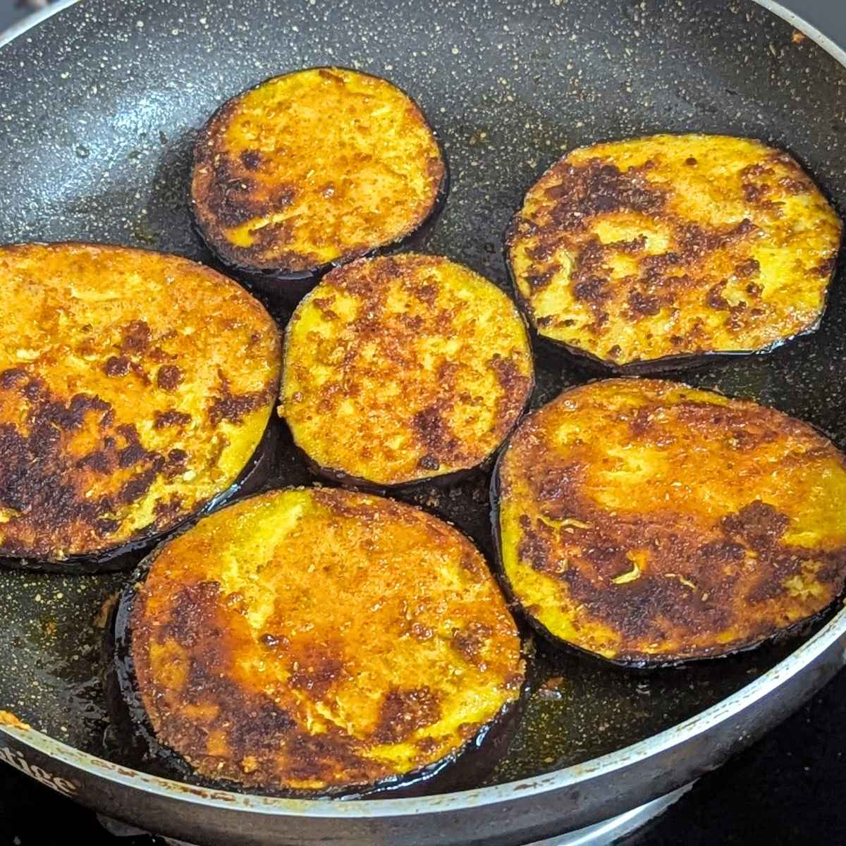 Seasoned eggplant slices after shallow frying in pan