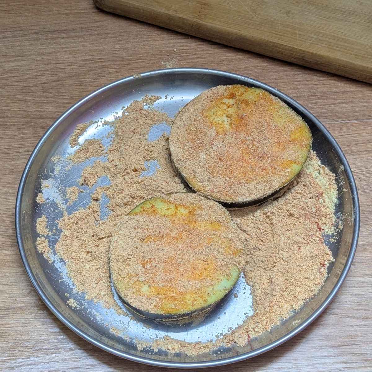 Eggplant slices with seasoning mix on a plate