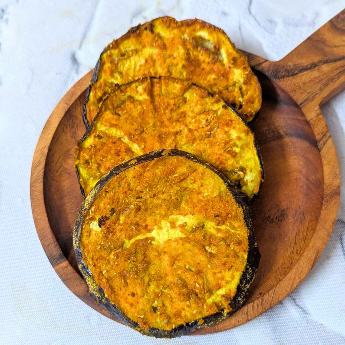 3 eggplant slices after air frying in a shallow plate