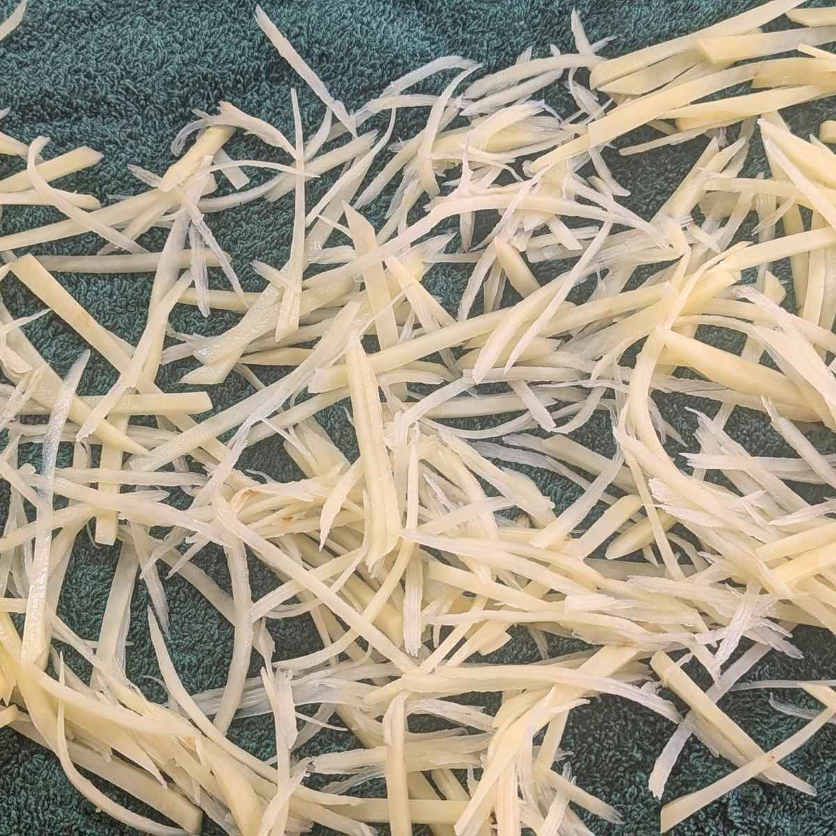 shoestring fries being dried on a towel