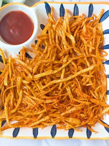 Shoestring fries served in a plate with ketchup