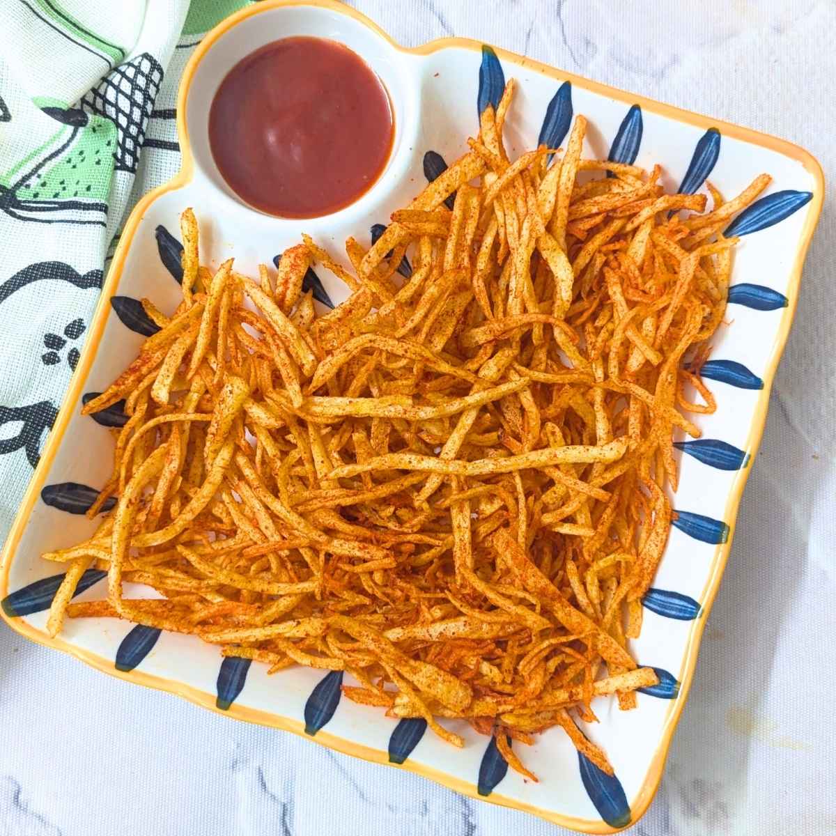 Shoestring fries served in a plate with ketchup