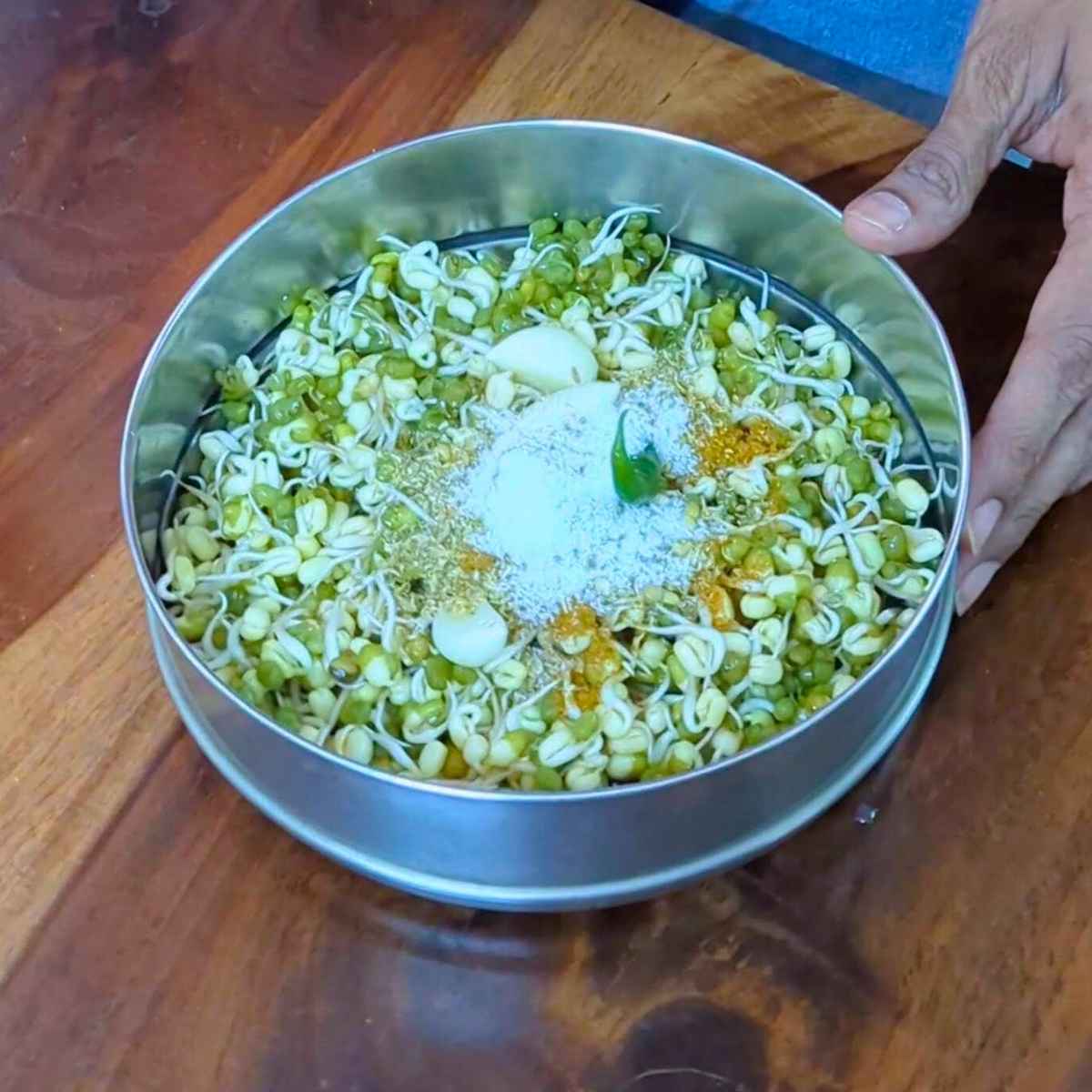 Sprouted moong with garlic, green chilli, salt and spices in a bowl.