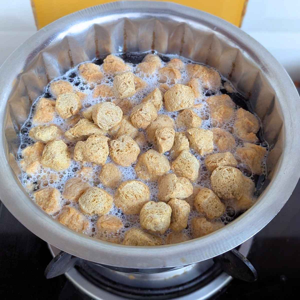 Soya chunks being boiled in water in a pan