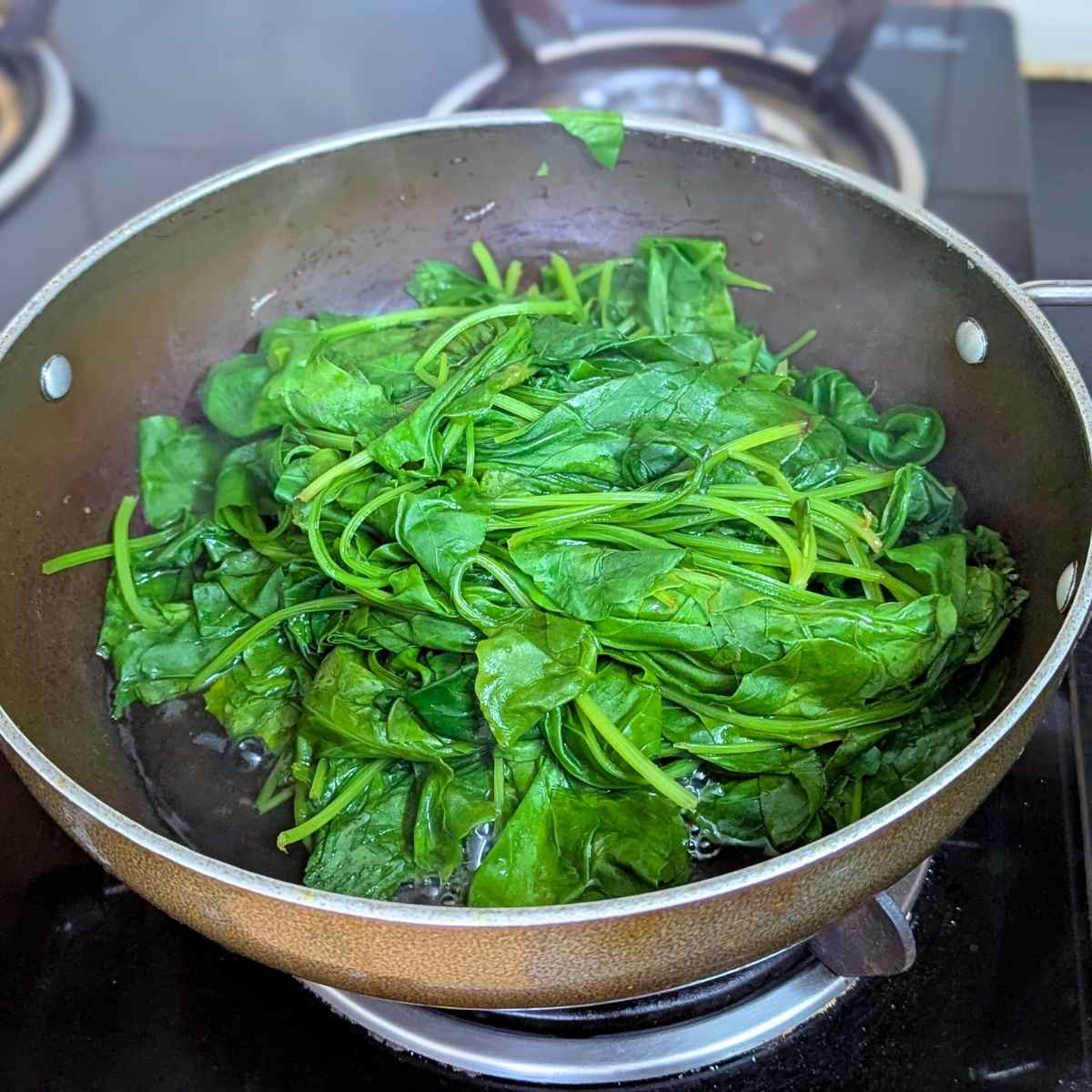 Spinach leaves wilted after cooking in a pan.