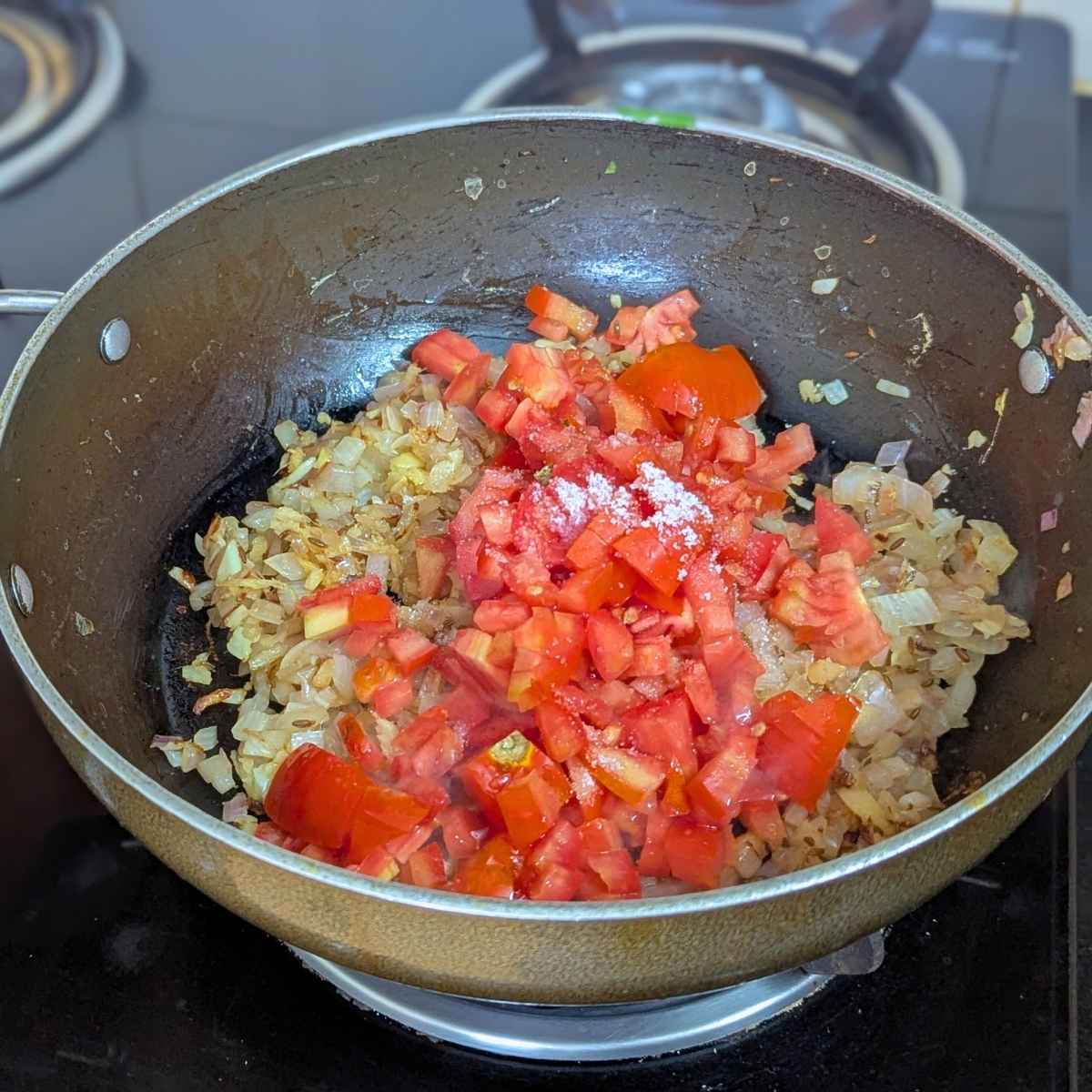 Onions and tomatoes in a pan.
