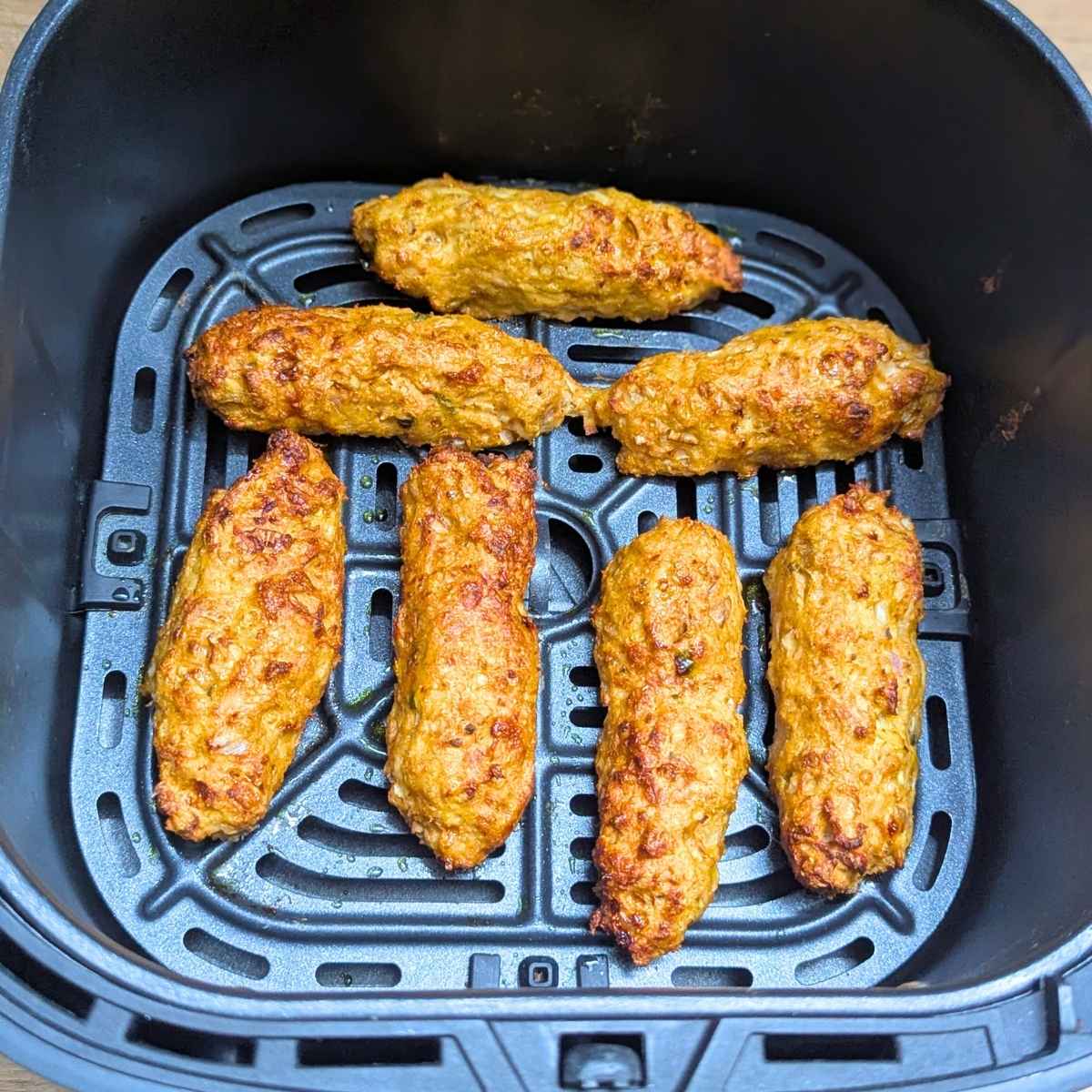 Chicken seekh kebab after air frying in air fryer basket.