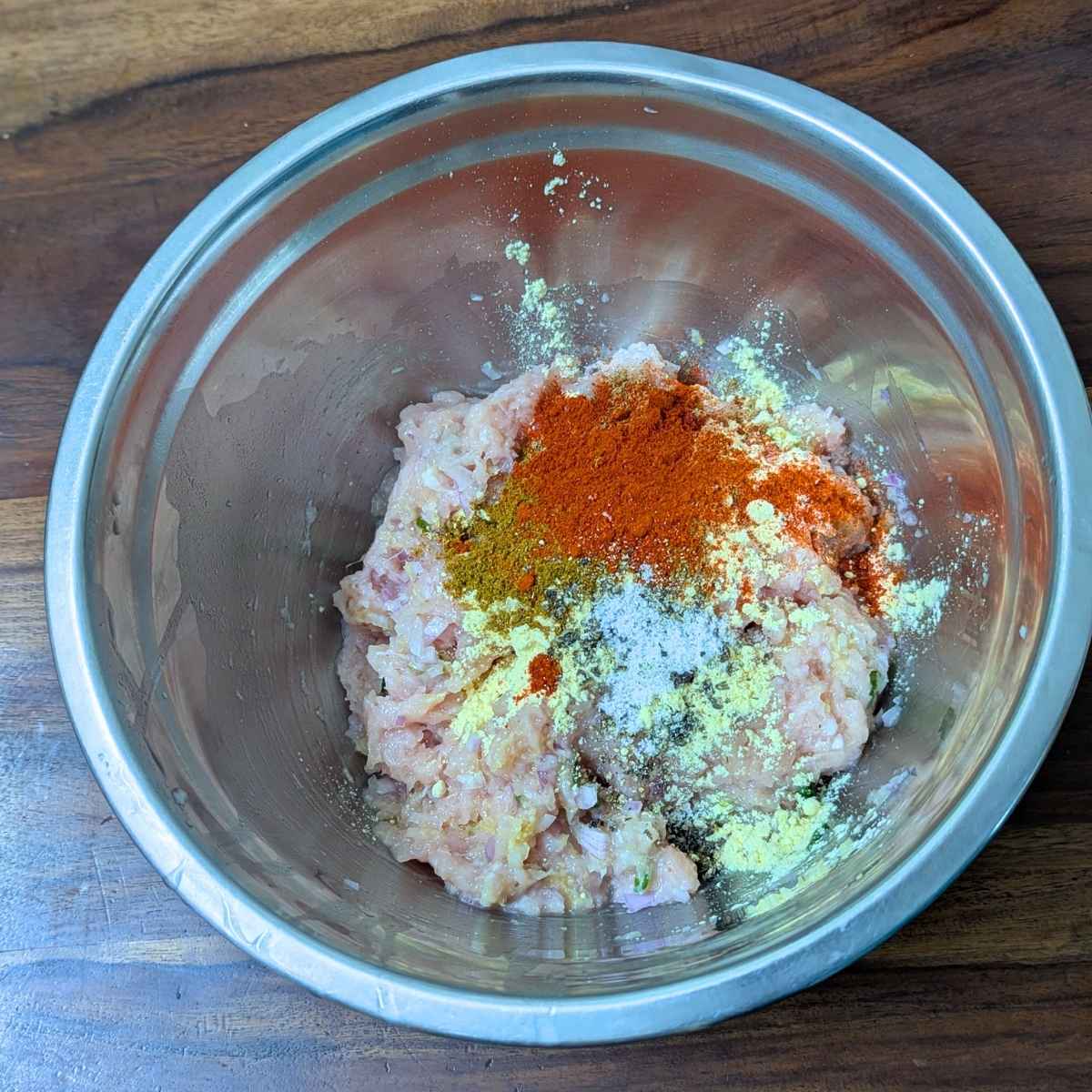 Spices and chickpea flour added to chicken mince