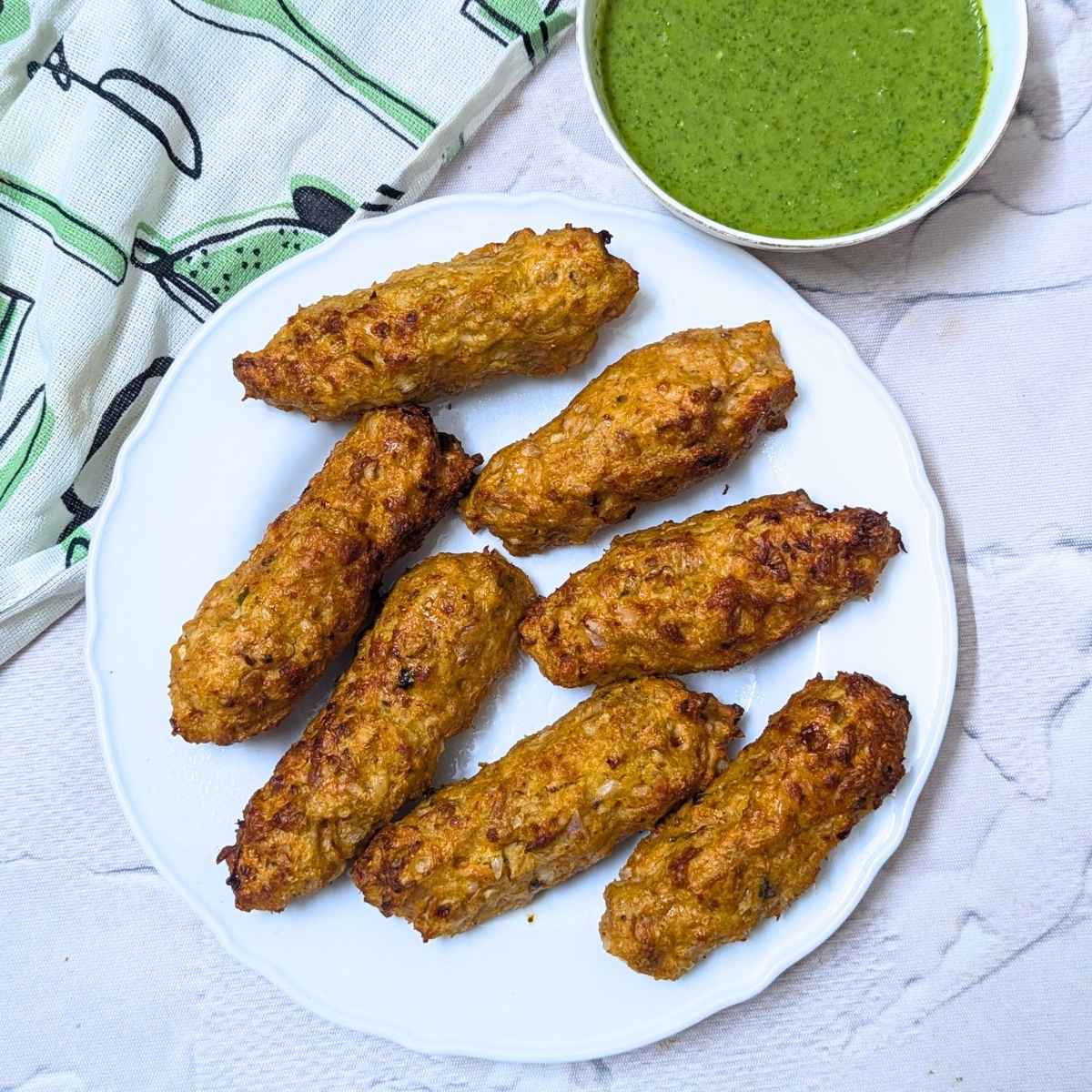 chicken seekh kebab served in a plate with mint chutney