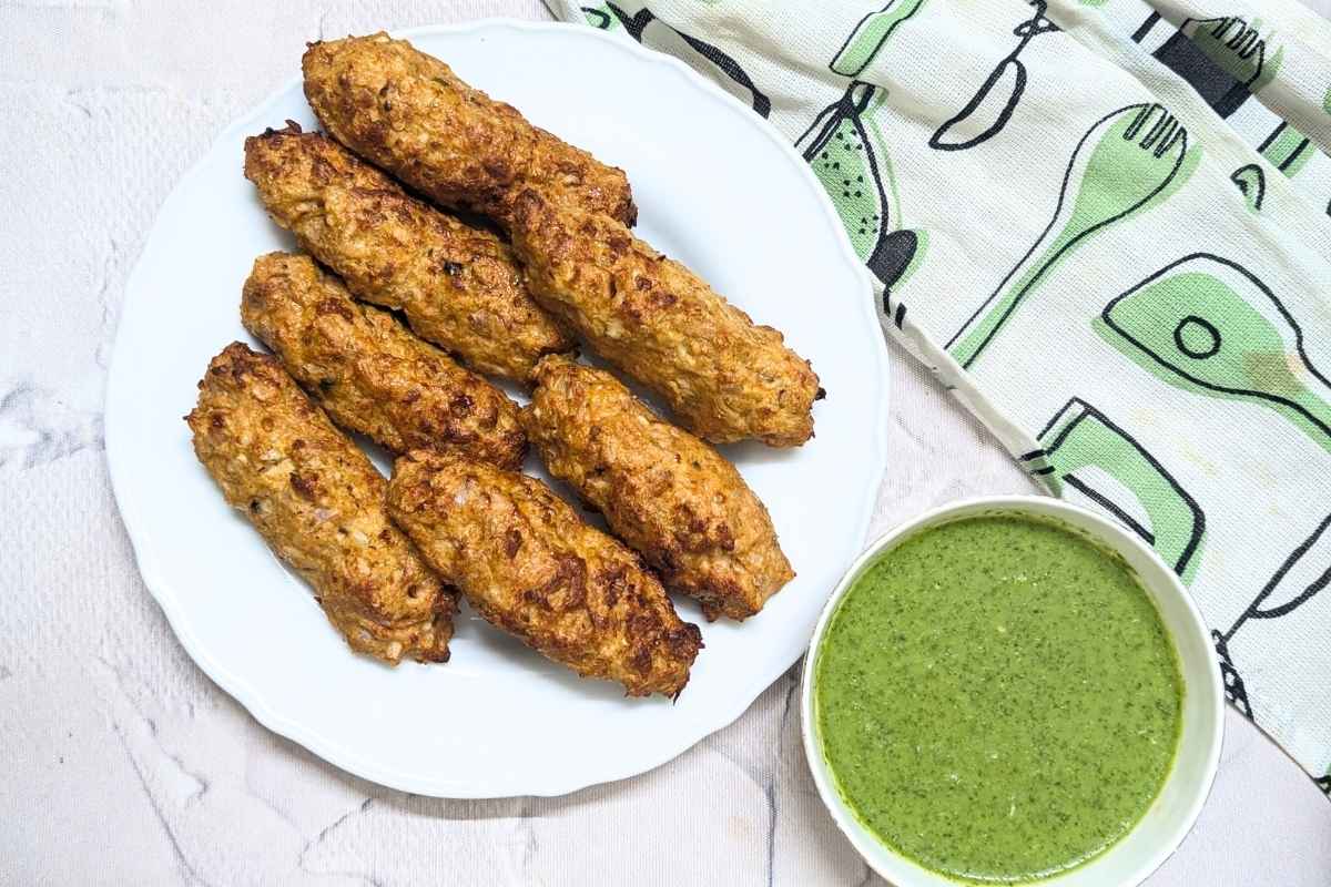 Chicken seekh kebab served in a plate with a bowl of chutney