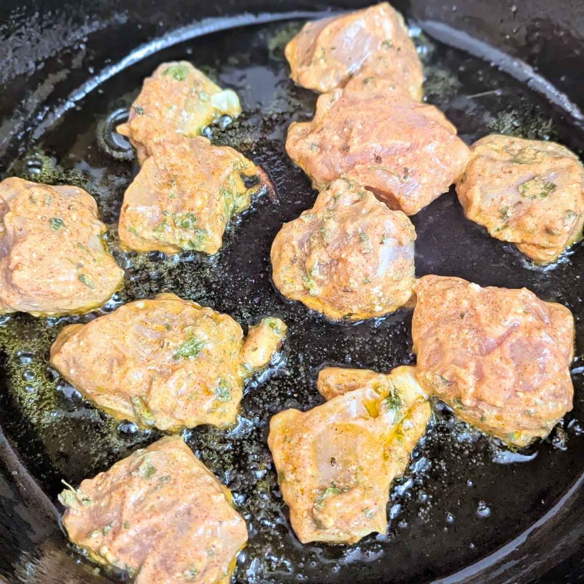 Chicken tikka being cooked in a skillet