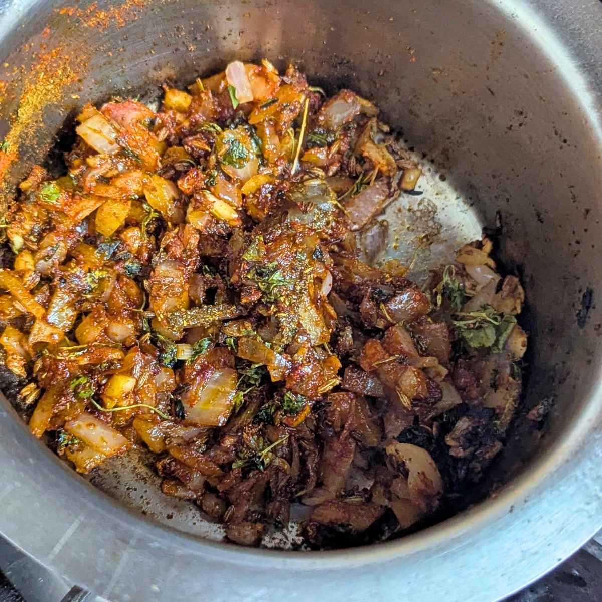 The seasoning for maa ki dal in a pan includes onion, garlic, spices and ghee