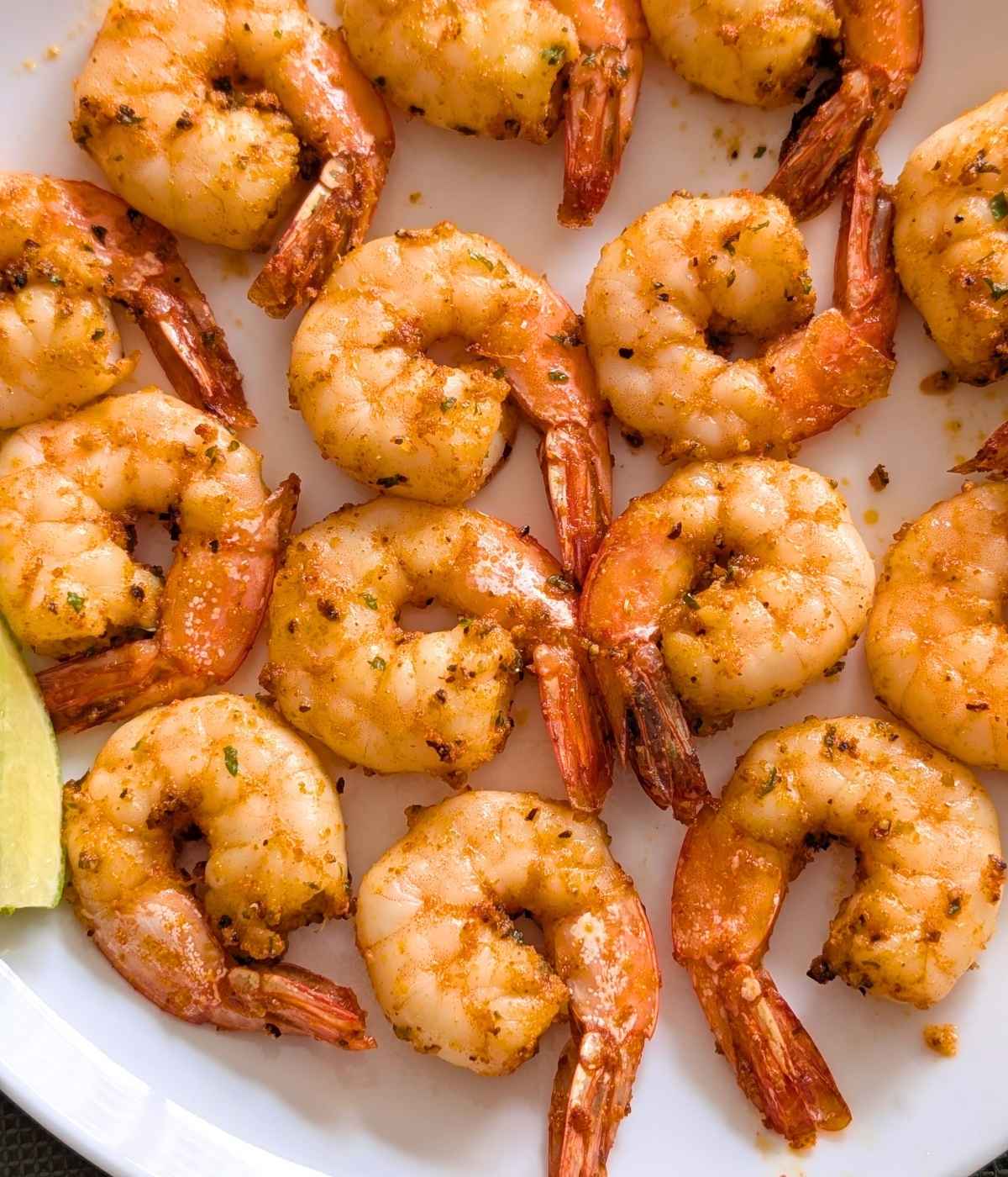Close up of crispy air fried shrimp served on a white plate.
