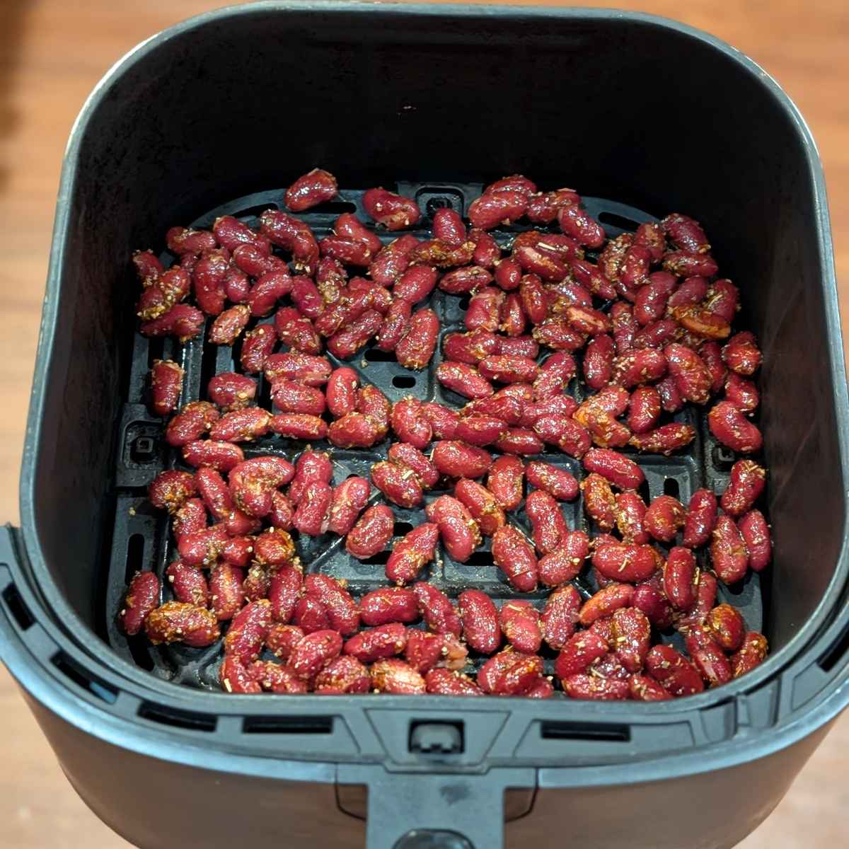 Kidney beans tossed with seasonings and olive oil in air fryer basket