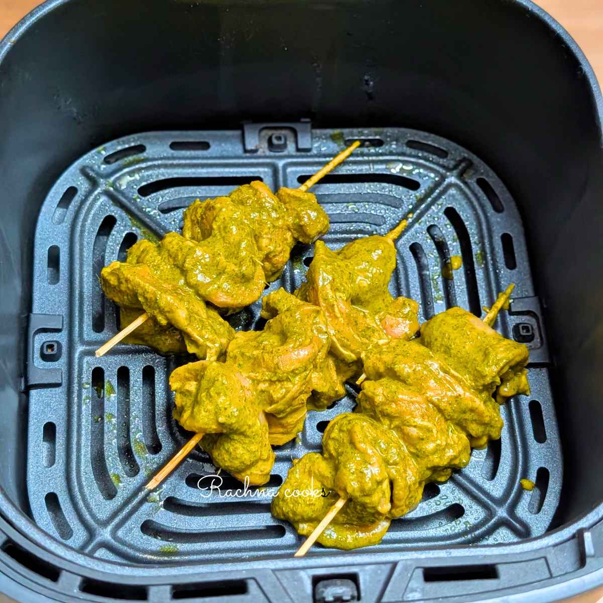 Skewers with green chicken bites in air fryer basket