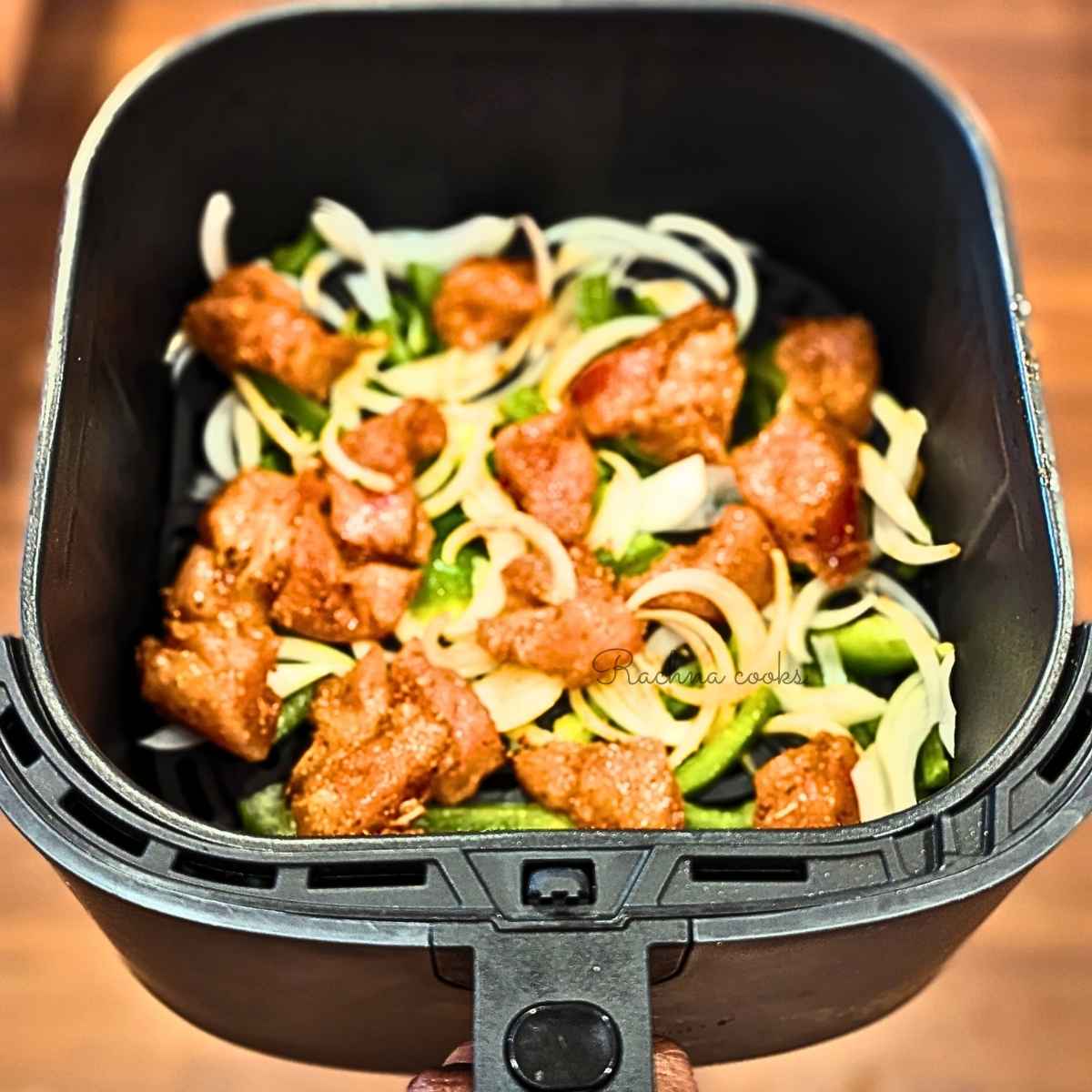 Marinated chicken with peppers and onion in air fryer basket