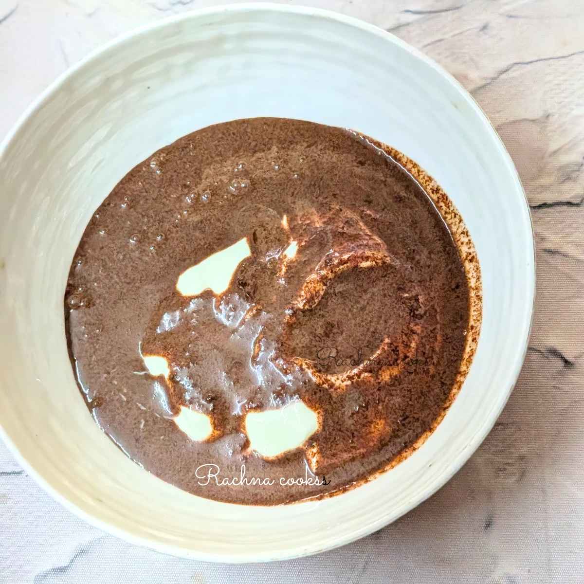 Dark chocolate mixture added to Greek yogurt in a bowl