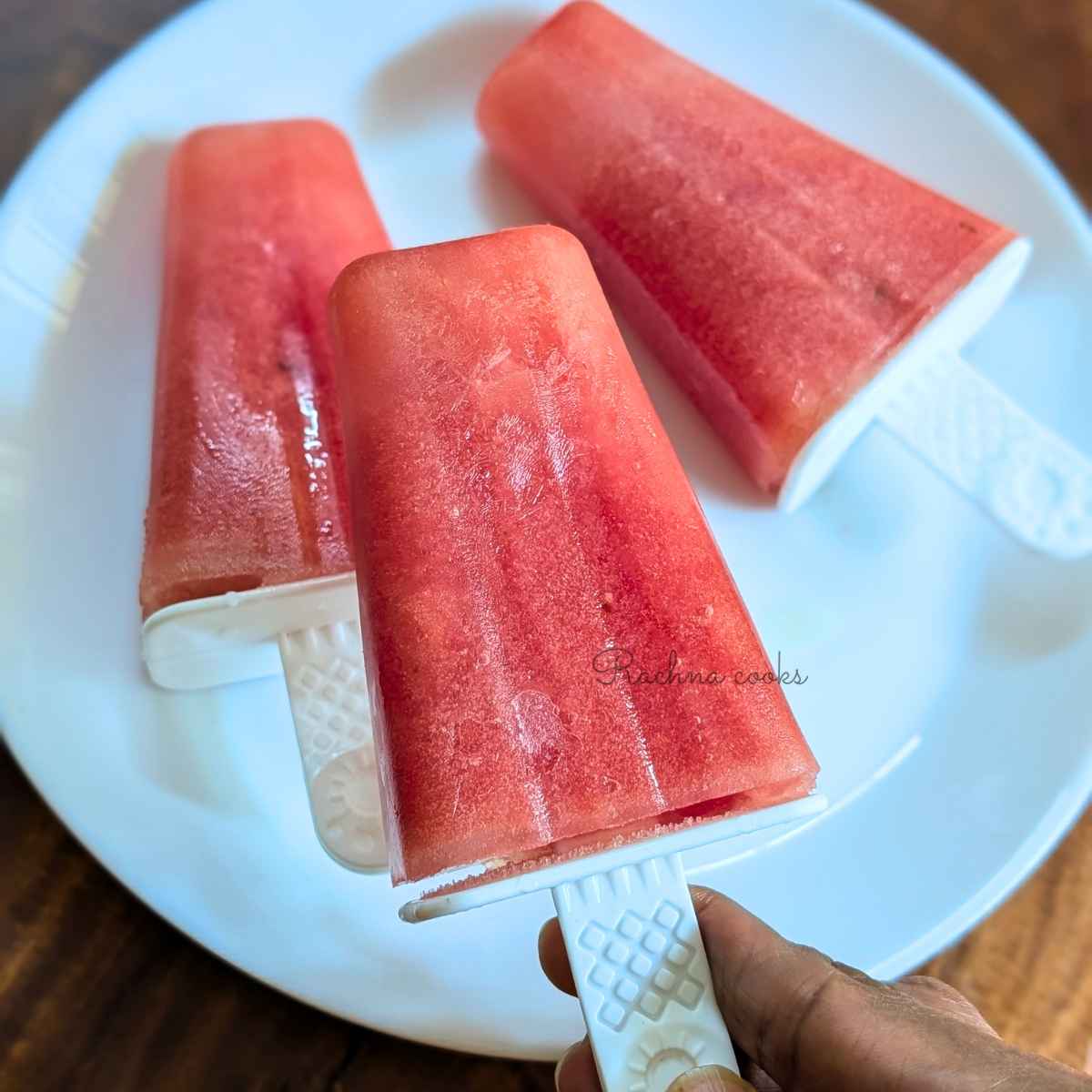 3 watermelon popsicle sticks on a plate.