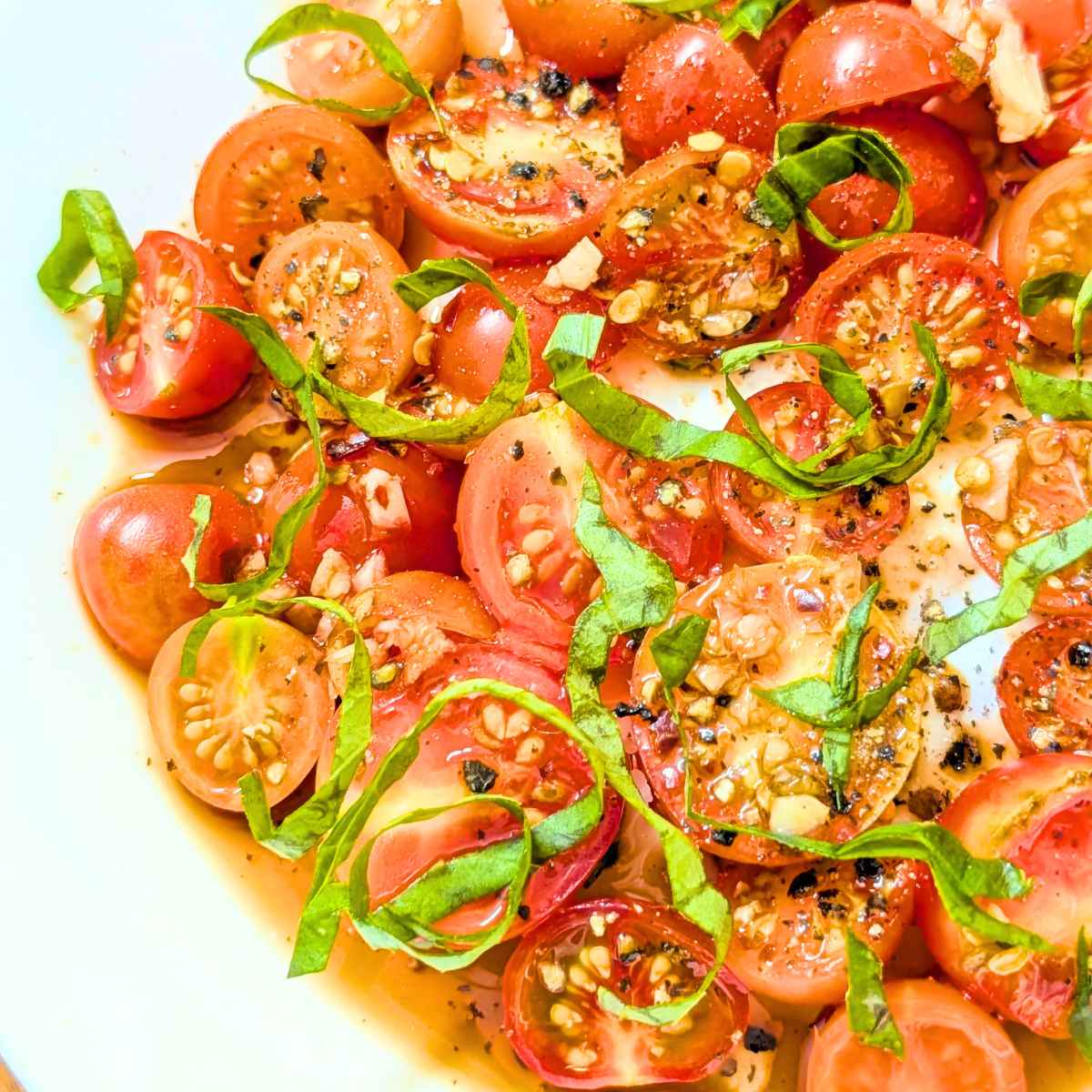 close up of basil and cherry tomato salad