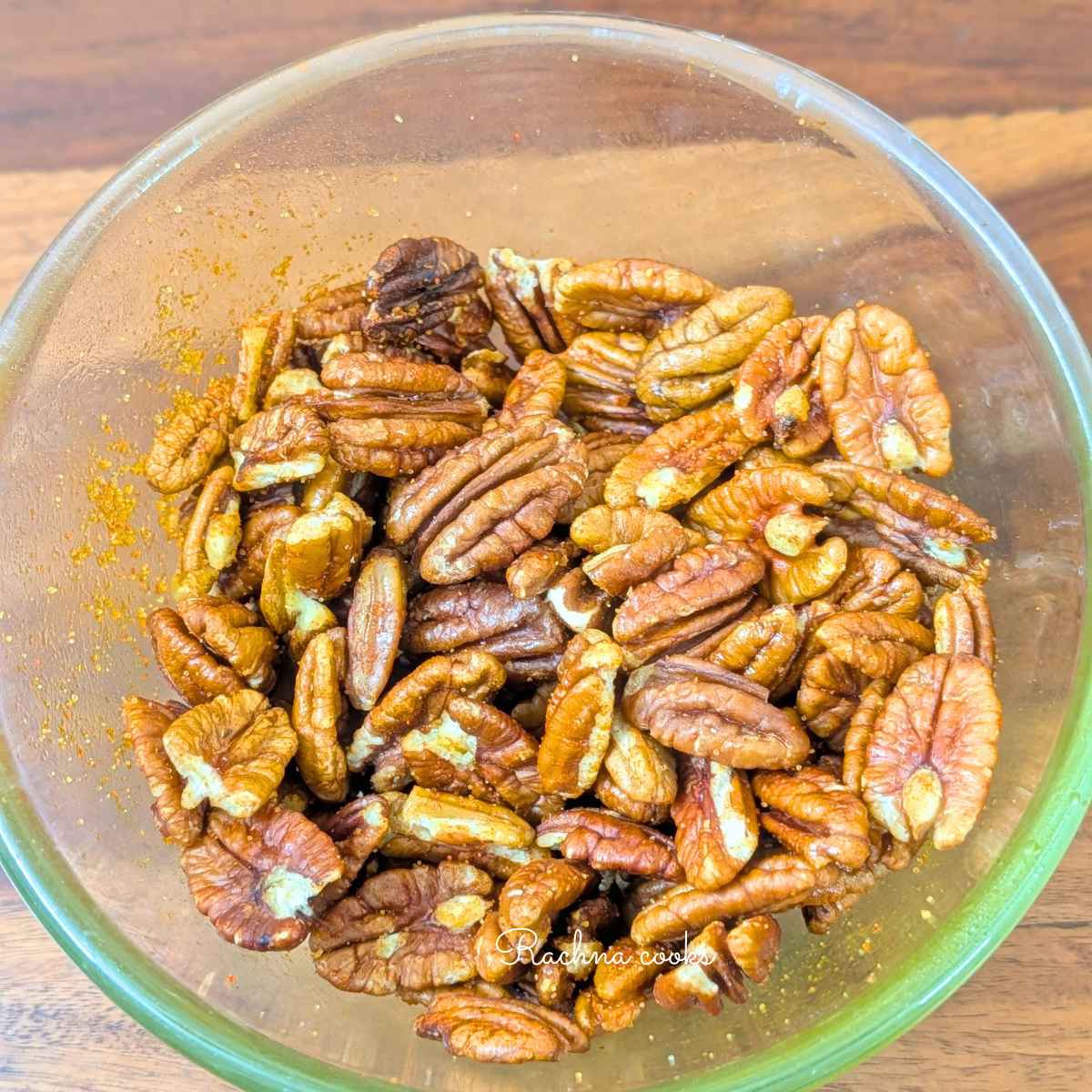Pecans in bowl after adding seasonings and olive oil and tossing them