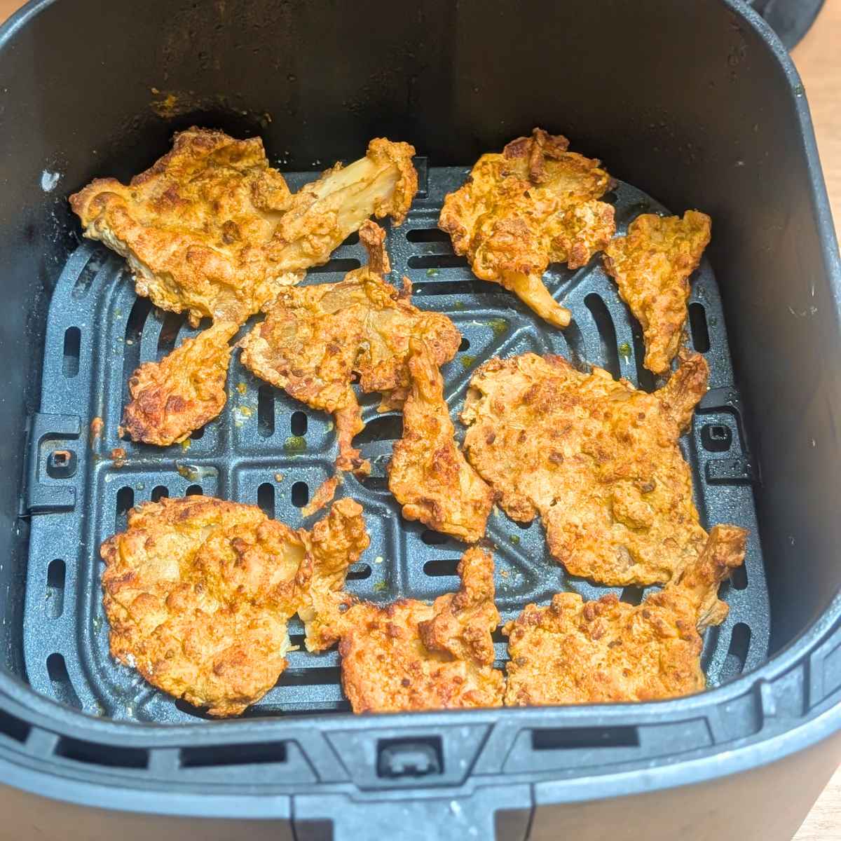 Oyster mushrooms after air frying in air fryer basket.