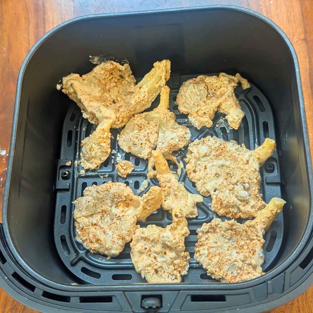 Oyster mushrooms after air frying in air fryer basket.