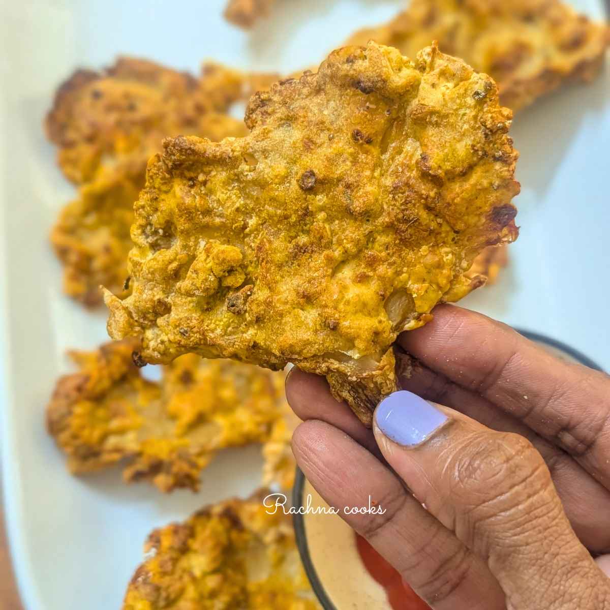 An air fried oyster mushroom held up in hand