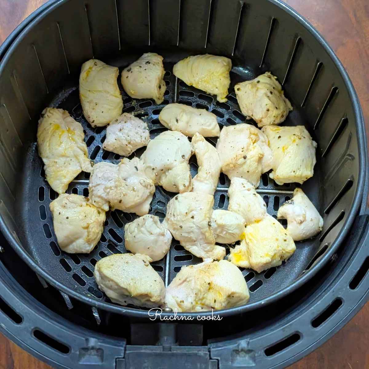 After air frying, chicken bites are visible in air fryer basket