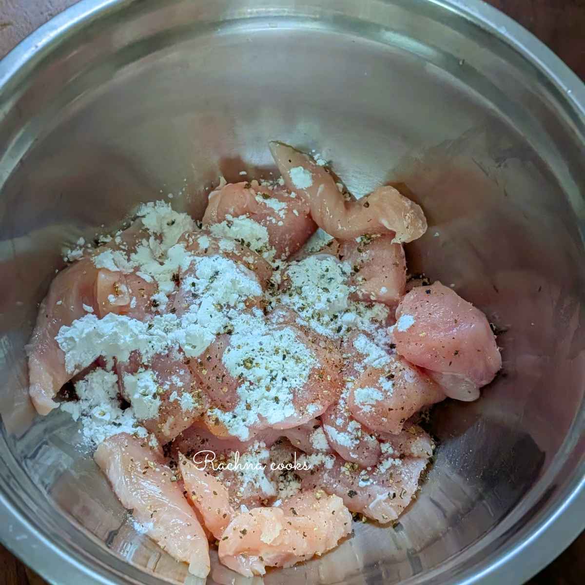 Chicken bites tossed with cornstarch, salt, pepper and garlic powder in a bowl