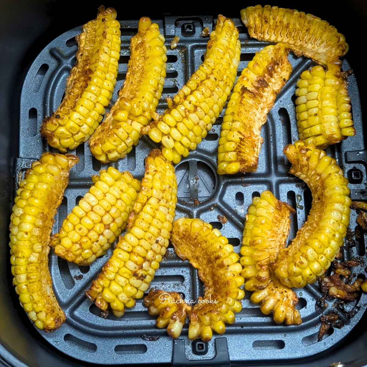 Golden brown curled up air fried corn ribs in air fryer basket.