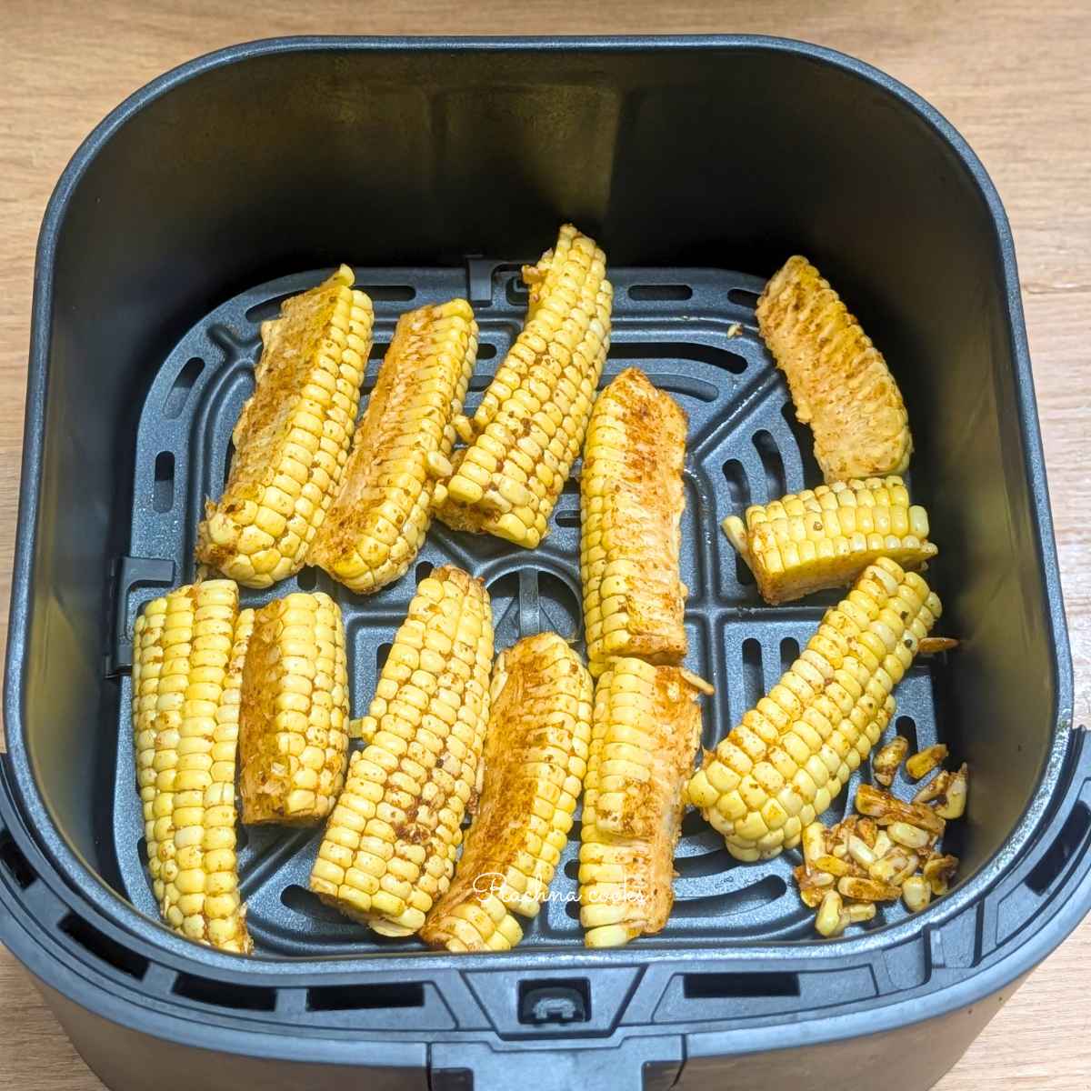 Corn ribs after brushing with olive oil and seasonings laid out in a single layer in air fryer basket