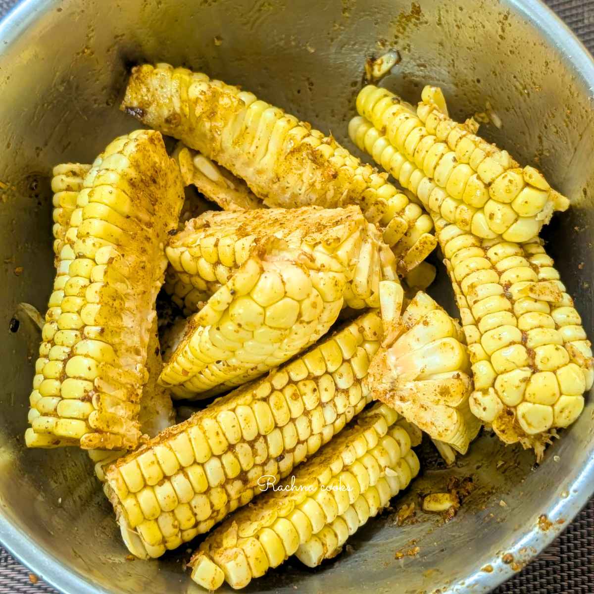 Corn ribs in a bowl after tossing with oil and seasonings.