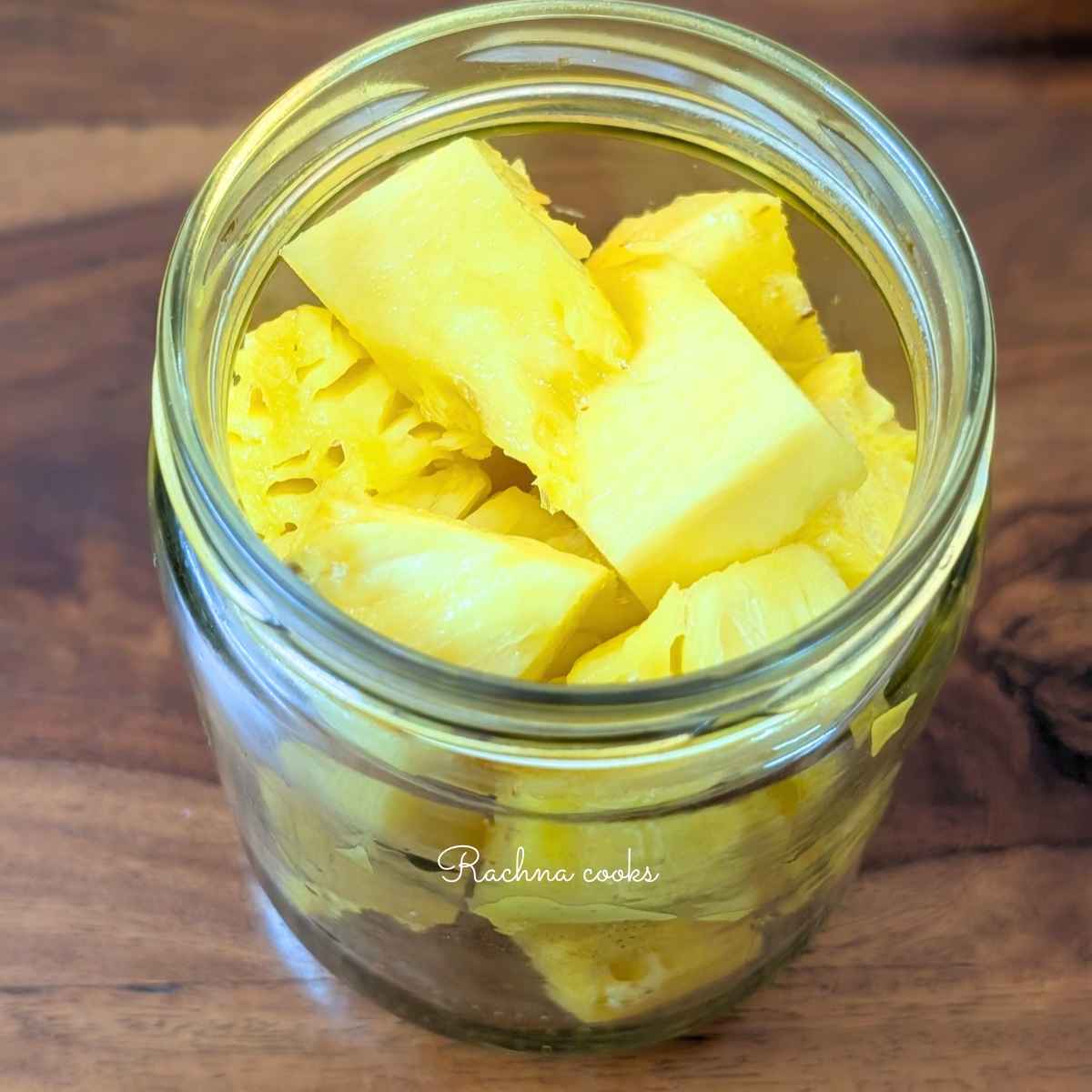 Cut pineapple chunks placed in a glass jar